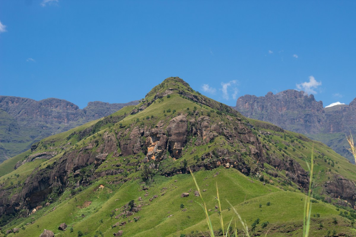 Green foothills beneath the Drakensberg mountain escarpment
